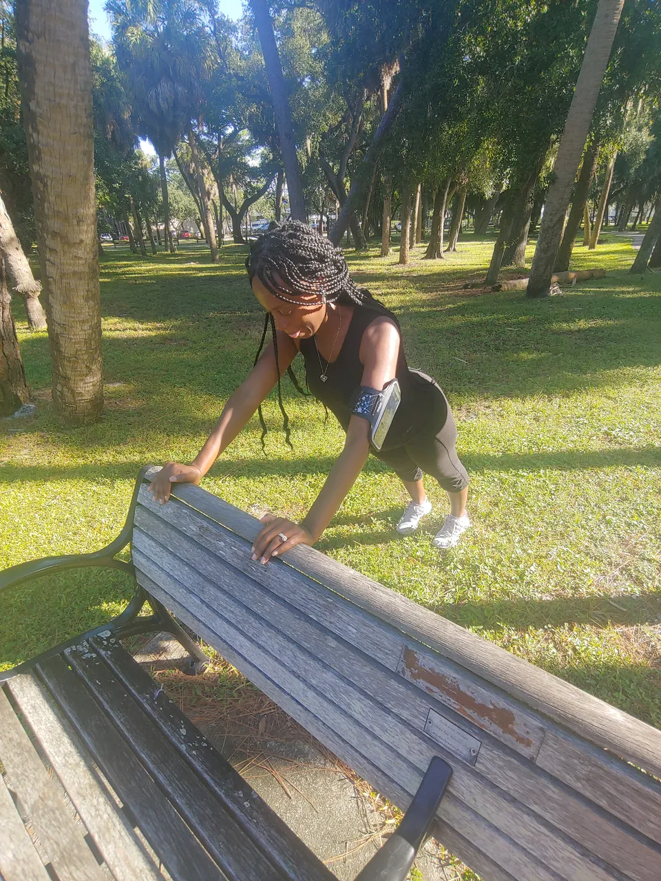 Toni doing a bodyweight incline push-up on a park bench
