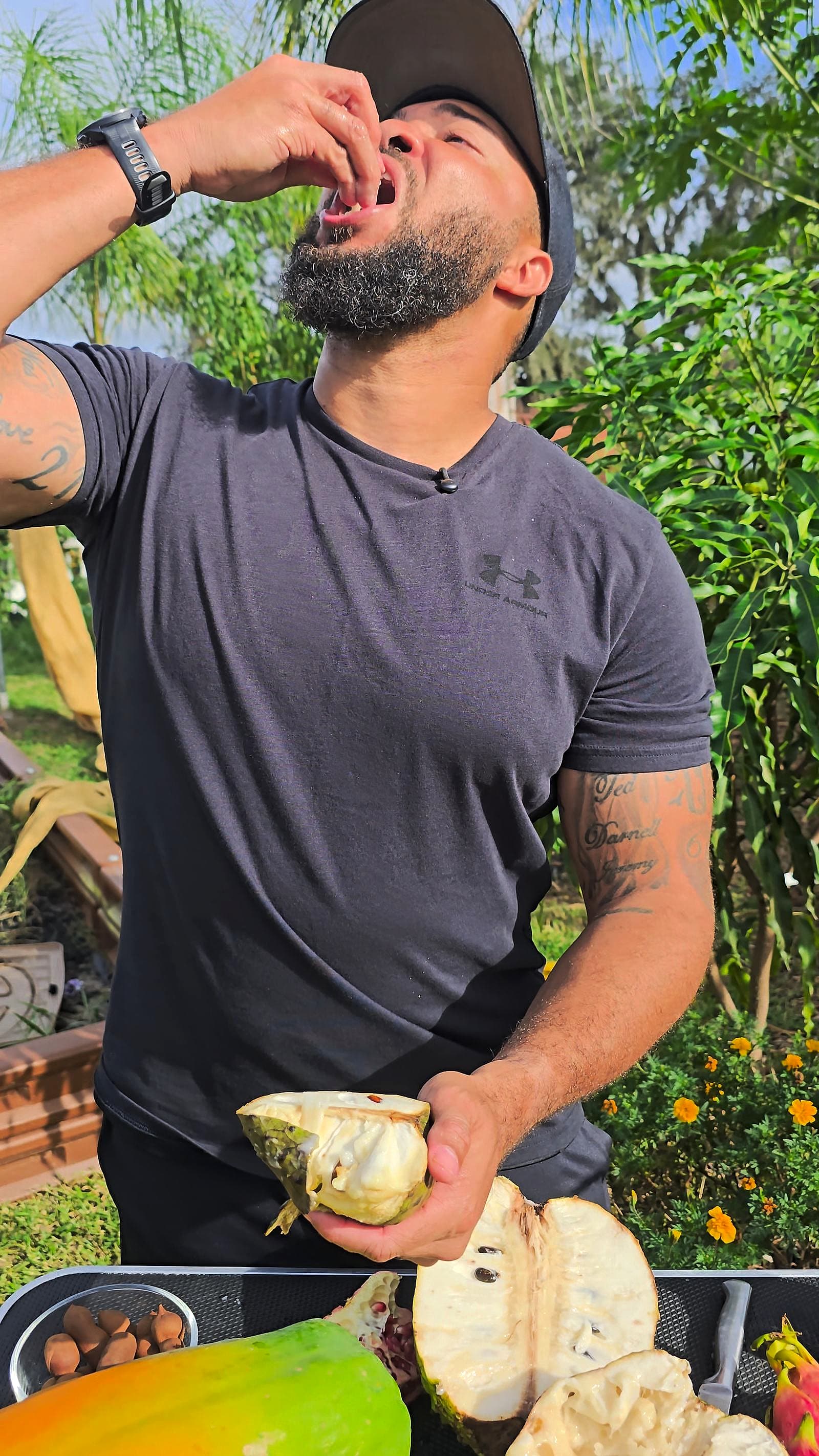 Jermaine tasting fruit fresh from the GrowFitFL backyard